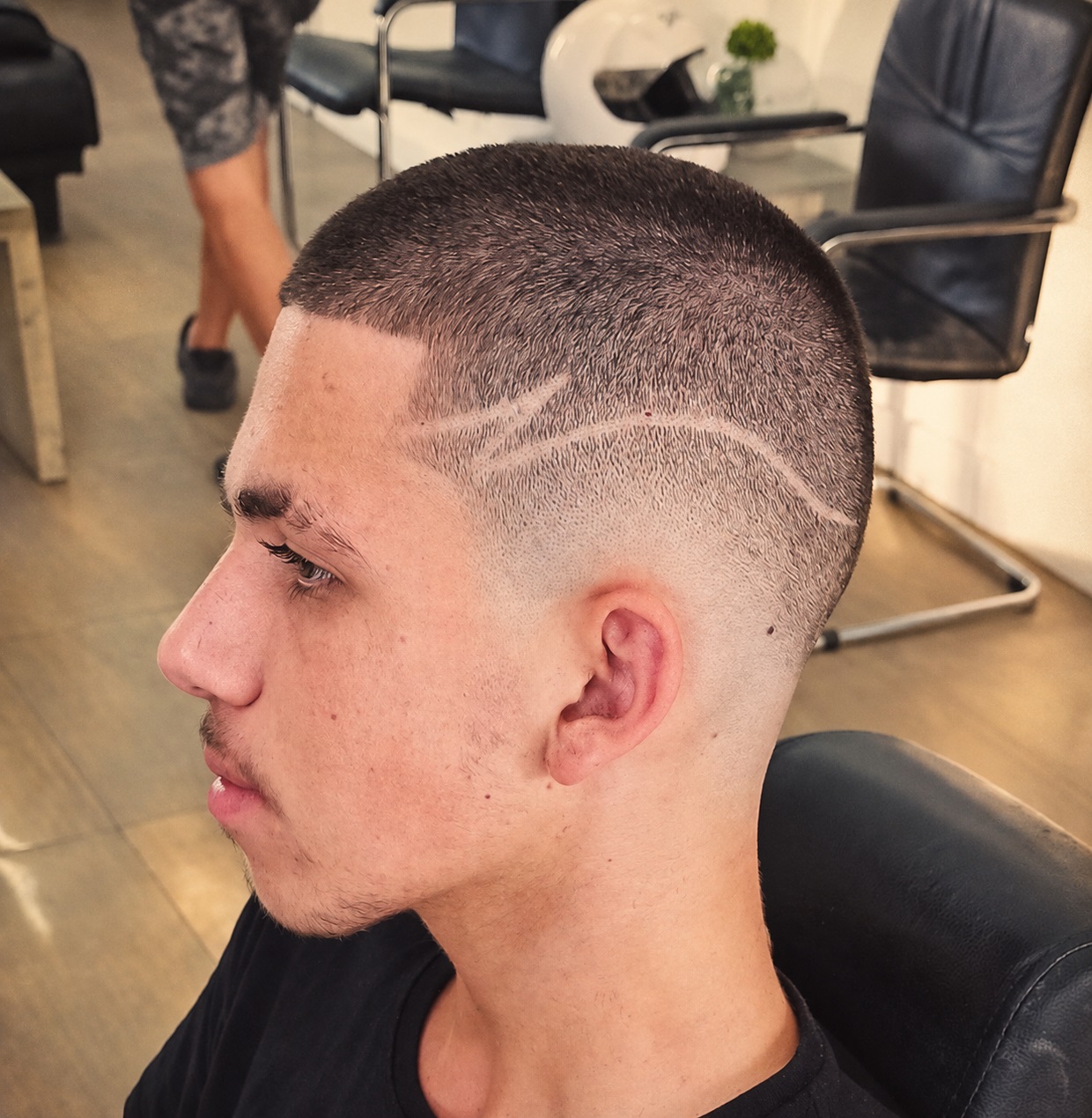 Young man with a curly burst fade mullet and shaved lines