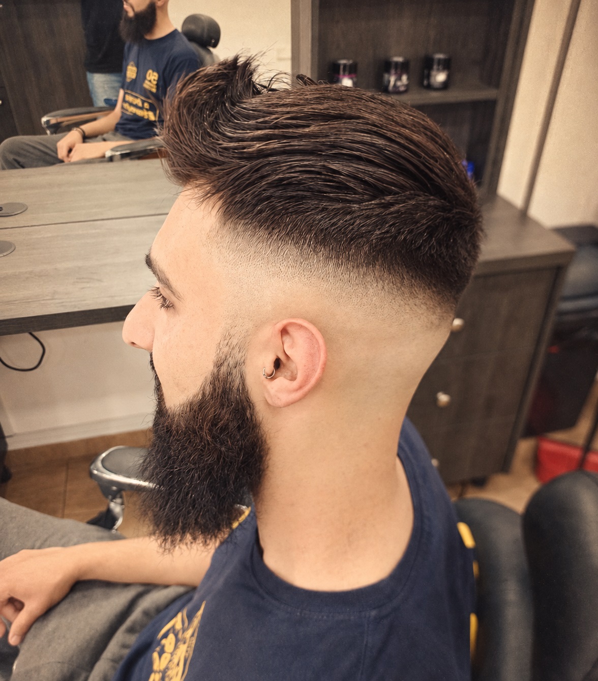 Man with a thick beard and high-volume pompadour with skin fade